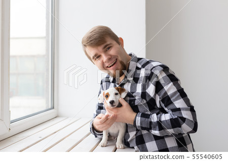 People, pet and dog concept - Close up portrait of man holding a cute jack russell terrier puppy 55540605