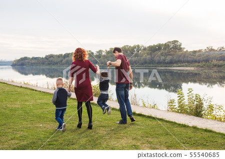 Parent, childhood and nature concept - Family playing with two sons by the water 55540685