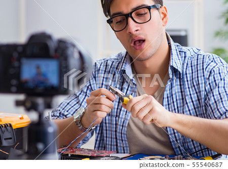 Vlogger recording computer repair on camera for vlog blog 55540687