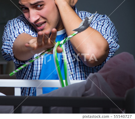 Young father under stress due to baby crying at night Young father under stress due to baby crying at night 55540727