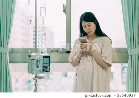 lady patient in pajamas holding cellphone 55540937