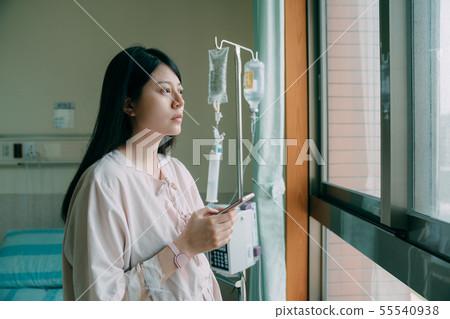 woman at hospital room holding mobile phone. 55540938