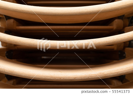 A closeup of folded light colour wooden folding chairs A closeup of folded light colour wooden folding chairs 55541373