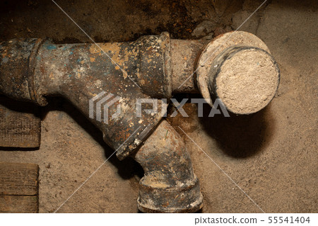 Worn out rusty water pipe in a concrete wall Worn out rusty water pipe in a concrete wall 55541404