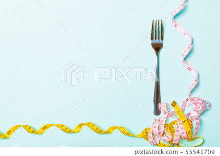 Top view composition of fork and curled measuring Top view composition of fork and curled measuring 55541709