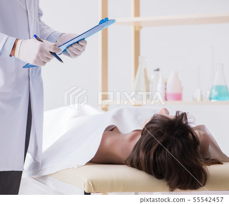 Police coroner examining dead body corpse in morgue 55542457