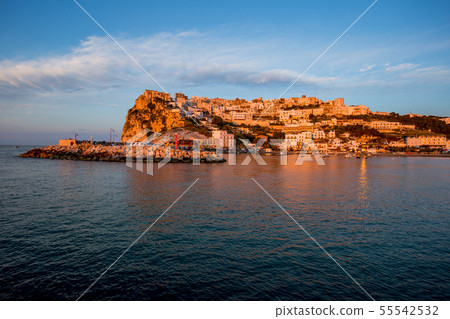 Setting sun lit city over the sea Setting sun lit city over the sea 55542532