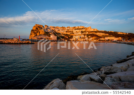 Setting sun lit city over the sea Setting sun lit city over the sea 55542540