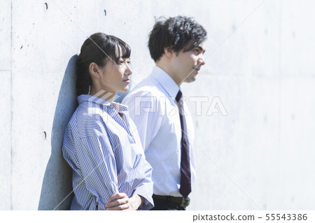 Man and woman standing in front of concrete wall 55543386