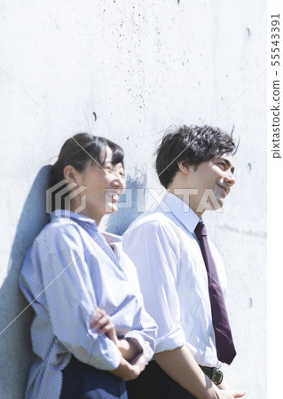 站立在混凝土牆前面的男人和婦女 55543391