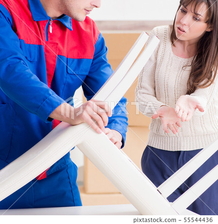 Contractor repairman assembling furniture under woman supervisio Contractor repairman assembling furniture under woman supervisio 55544436
