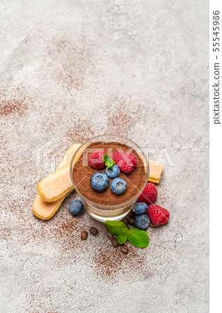 Classic tiramisu dessert with blueberries and raspberries and savoiardi cookies in a glass on Classic tiramisu dessert with blueberries and raspberries and savoiardi cookies in a glass on 55545986