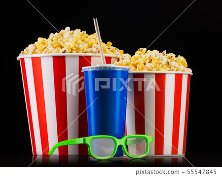 Paper striped bucket with popcorn, cup of drink and glasses isolated on black 55547845