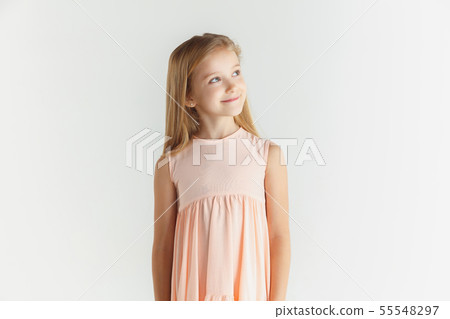 Little smiling girl posing in dress on white studio background Little smiling girl posing in dress on white studio background 55548297