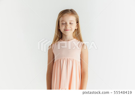 Little smiling girl posing in dress on white studio background Little smiling girl posing in dress on white studio background 55548419