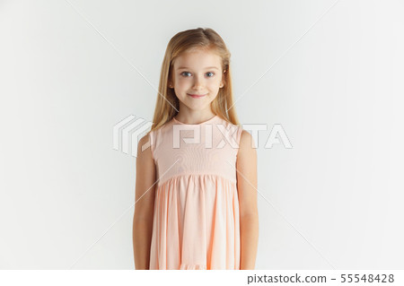 Little smiling girl posing in dress on white studio background Little smiling girl posing in dress on white studio background 55548428