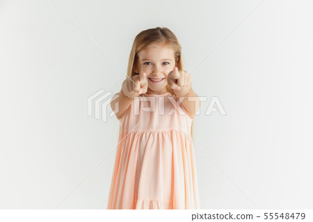 Little smiling girl posing in dress on white studio background 55548479