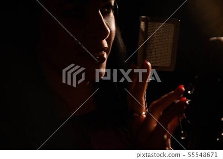 Woman singer singing a song in the recording studi Woman singer singing a song in the recording studi 55548671