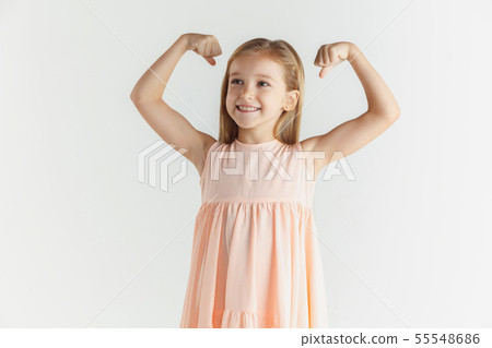 Little smiling girl posing in dress on white studio background 55548686
