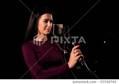 Singer recording a song in music studio. Singer recording a song in music studio. 55548740