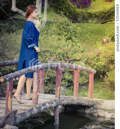 Beautiful woman on a bridge in the park 55549069