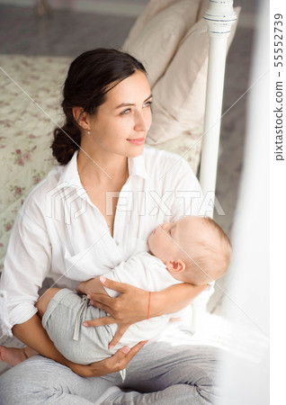 Young mother, holding tenderly her newborn baby 55552739