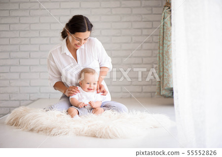 Mom and baby boy in playing in sunny bedroom Mom and baby boy in playing in sunny bedroom 55552826