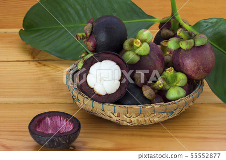 Ripe mangosteens (Garcinia mangostana) with green Ripe mangosteens (Garcinia mangostana) with green 55552877