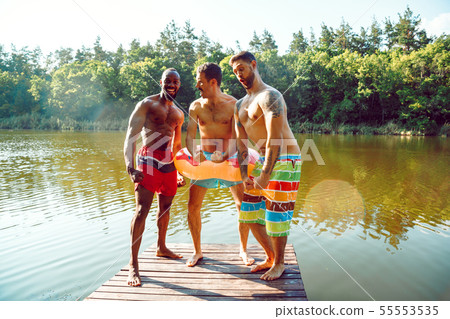 Happy friends having fun, ready to jump and swim in river Happy friends having fun, ready to jump and swim in river 55553535