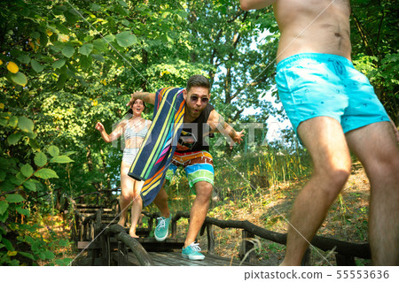 Group of happy friends having fun while running to swim on river Group of happy friends having fun while running to swim on river 55553636