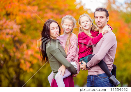 Beautiful happy family of four in autumn day outdoors Beautiful happy family of four in autumn day outdoors 55554962