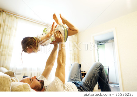 Father and daughter playing on the couch in the airplane.  55556253