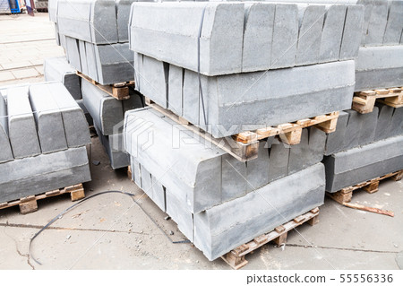 stockpiles of gray concrete curbs on street stockpiles of gray concrete curbs on street 55556336