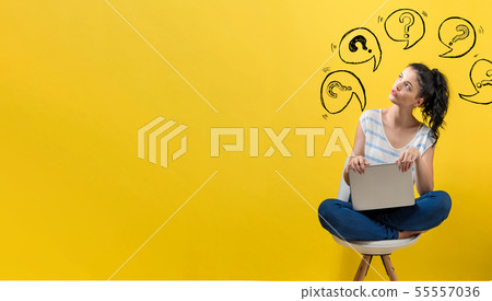 Question marks with speech bubbles with woman using a laptop 55557036