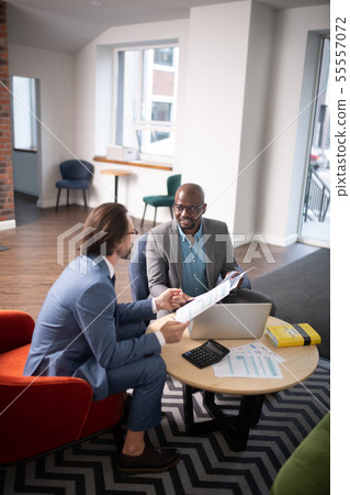 Businessman and economist sitting at the table and having negotiation 55557072