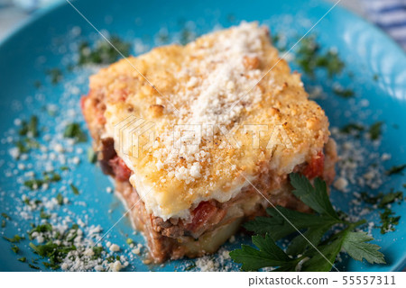 greek moussaka on blue plate in white wooden 55557311