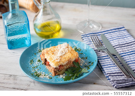 greek moussaka on blue plate in white wooden 55557312