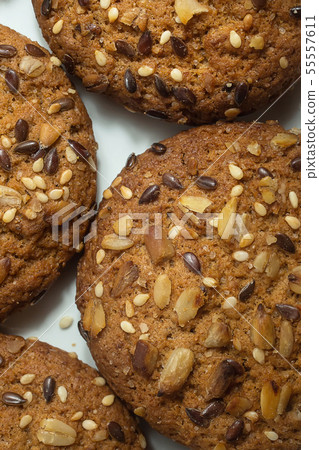 Macro photo of brown dietary low-calorie fitness cereal biscuits with sprinkling closeup on white Macro photo of brown dietary low-calorie fitness cereal biscuits with sprinkling closeup on white 55557611