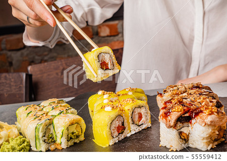woman eating sushi in the restaurant woman eating sushi in the restaurant 55559412