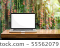 Laptop blank screen on wooden table red flowers 55562079