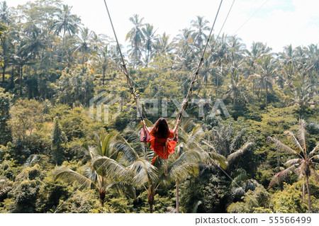 Young pretty Asian woman is swinging on the cliff Young pretty Asian woman is swinging on the cliff 55566499