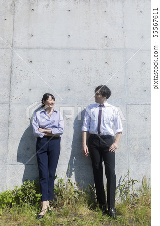 Man and woman standing in front of concrete wall 55567611