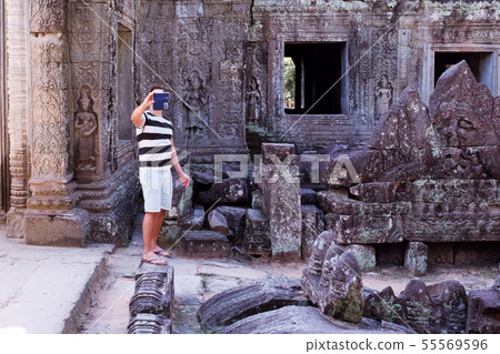 Tourist photographs a landmark on a mobile phone. Tourist photographs a landmark on a mobile phone. 55569596