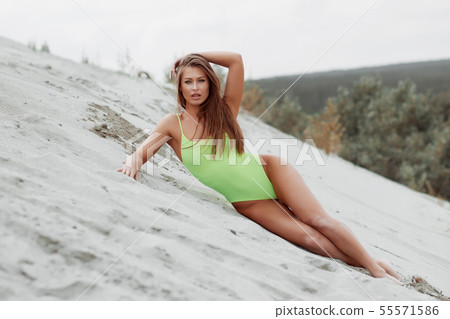 Seductive woman in stylish swimsuit kneeling in 55571586