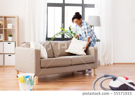 african american woman arranging sofa cushions african american woman arranging sofa cushions 55571933