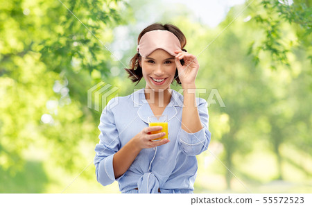 woman in pajama and sleeping mask with juice woman in pajama and sleeping mask with juice 55572523