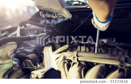 mechanic man with wrench repairing car at workshop mechanic man with wrench repairing car at workshop 55572616