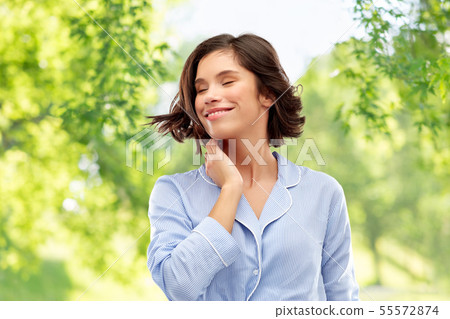 happy young woman in pajama over grey background 55572874