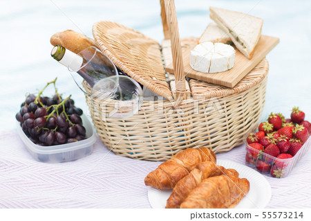 picnic basket, food and wine glasses on blanket 55573214
