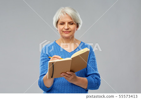 senior woman writing to diary or notebook senior woman writing to diary or notebook 55573413